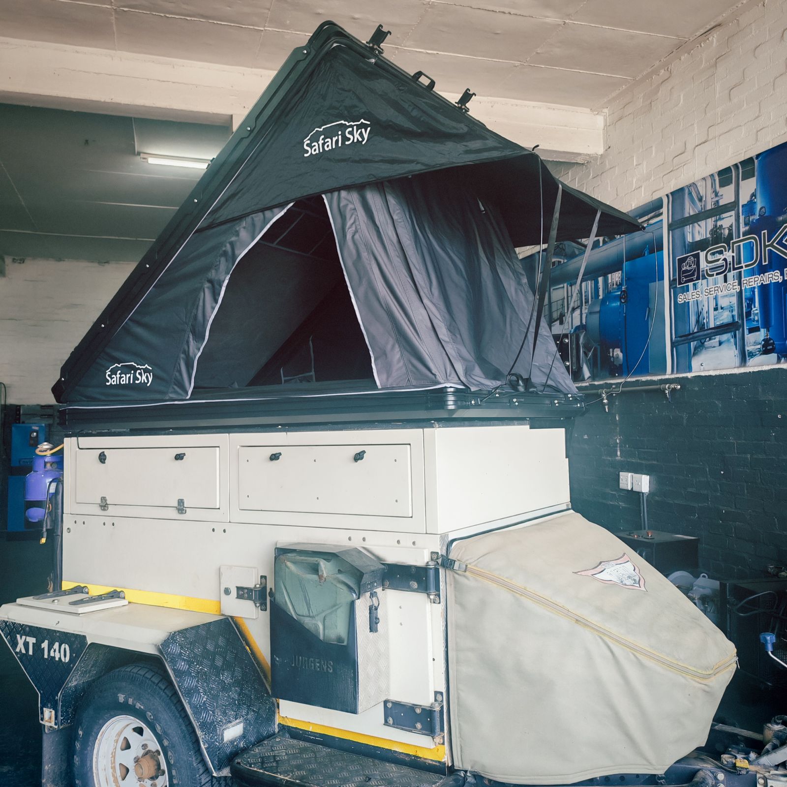 Safari Sky rooftop tent open on an XT 140 trailer in the workshop