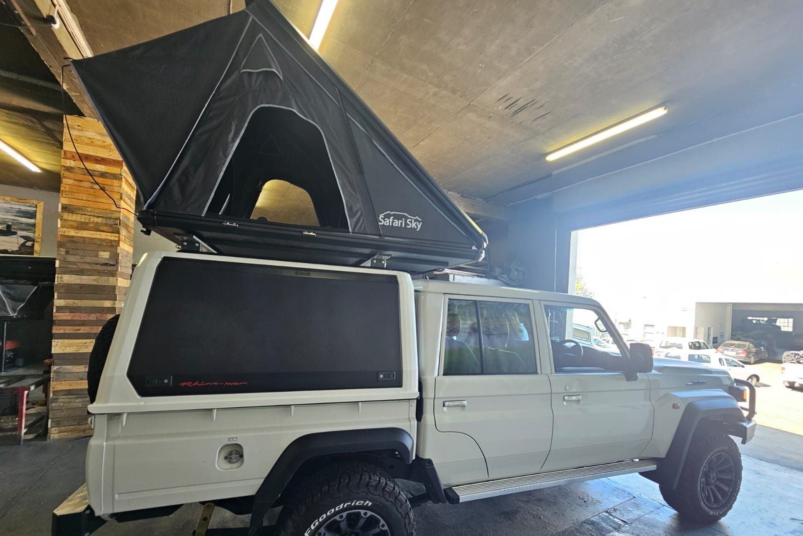 Safari Sky tent open on a white Land Cruiser 79 in the workshop