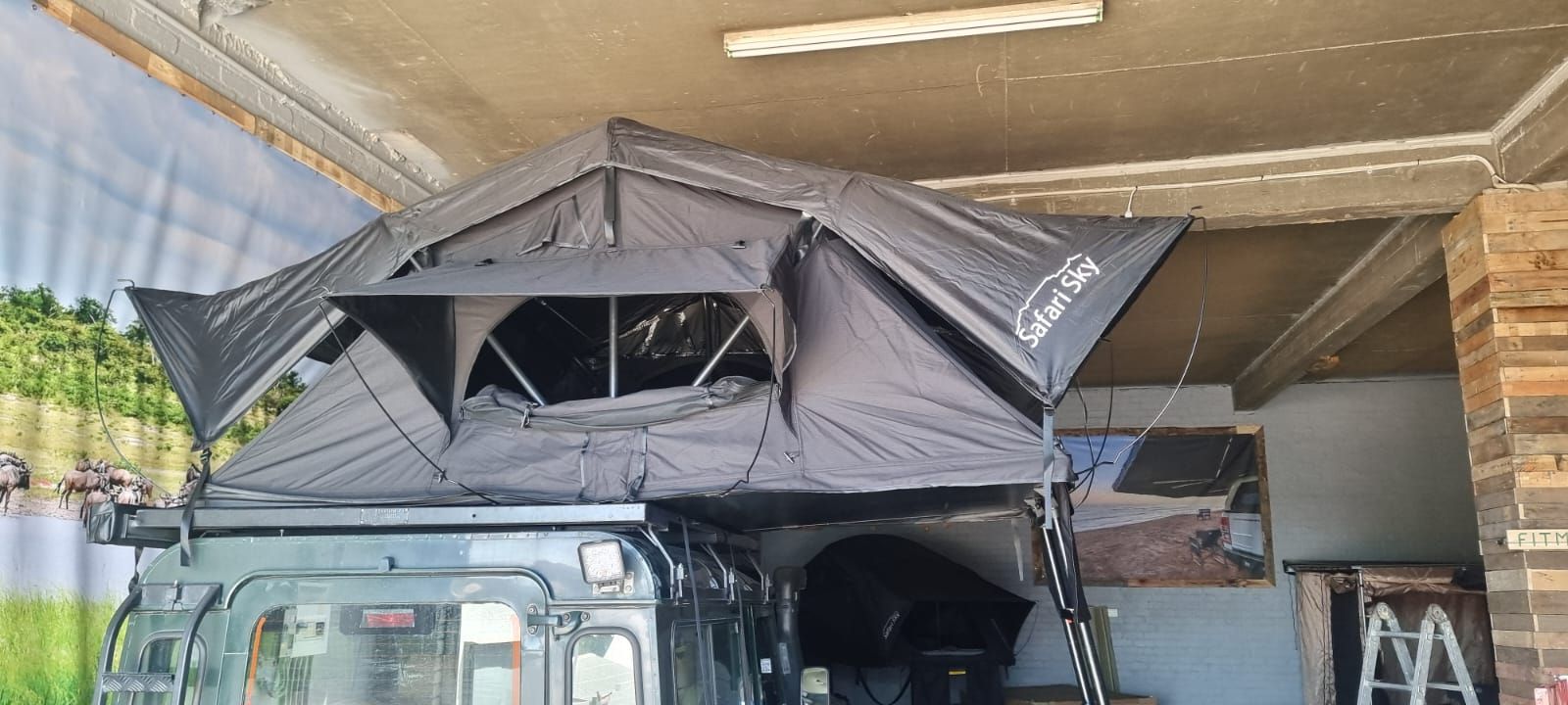 Safari Sky tent fully open on a Land Rover in the workshop
