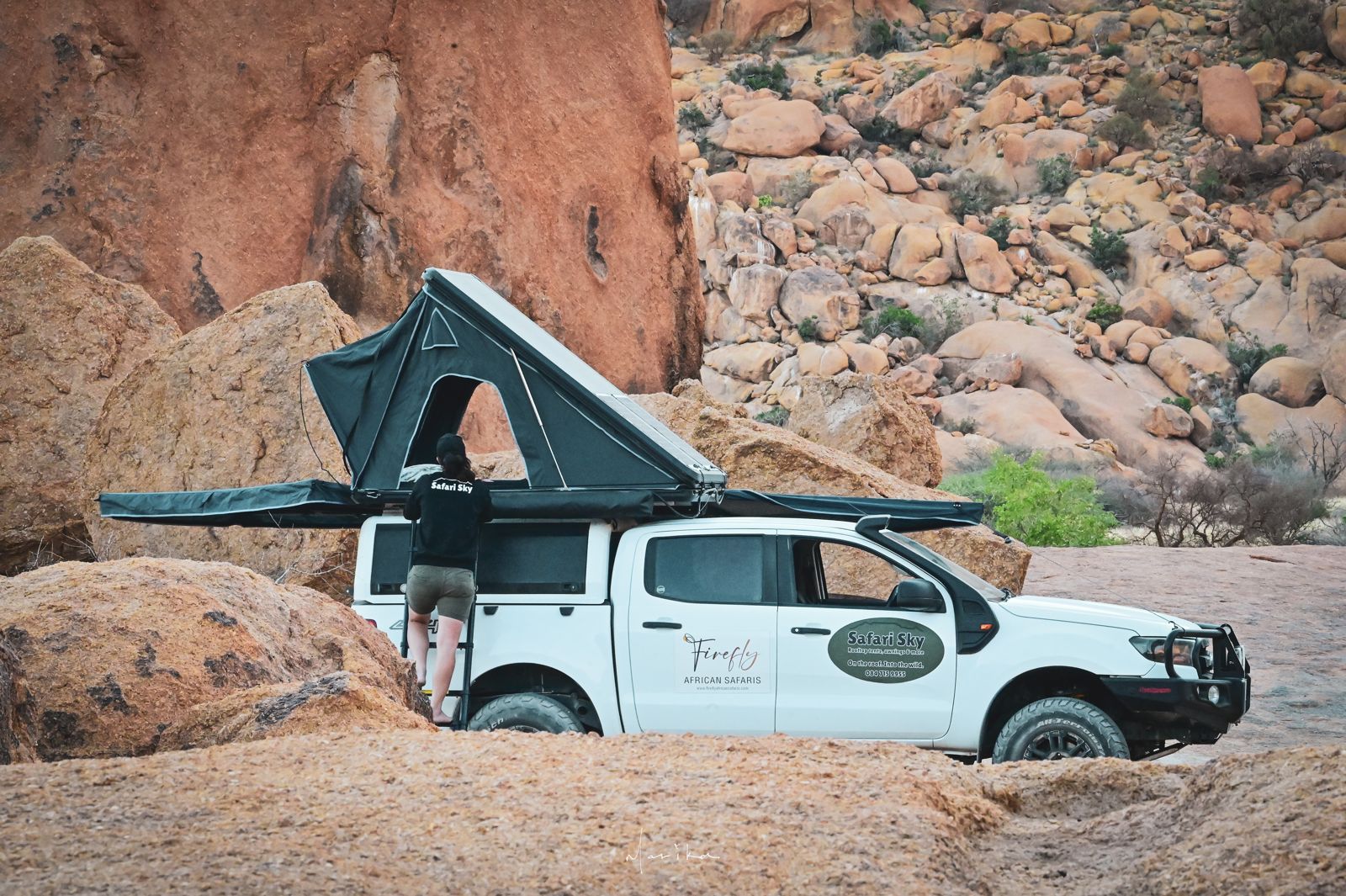 Climbing into the rooftop tent among the boulders