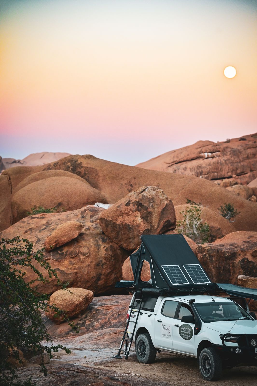 Safari Sky tent pitched among granite boulders at sunset in Namibia